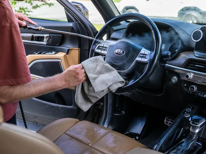 Microfiber towel following the steam wand across the steering wheel